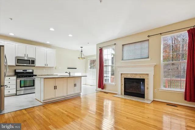 a large kitchen with cabinets wooden floor and a fireplace