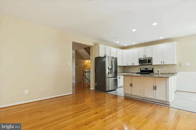a kitchen with stainless steel appliances a refrigerator and a stove top oven