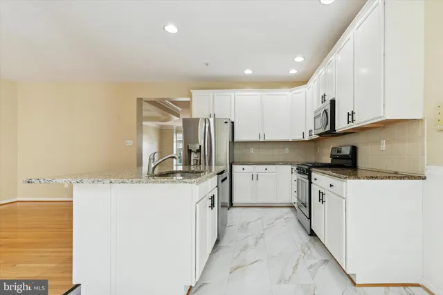 a kitchen with stainless steel appliances granite countertop a sink and a stove