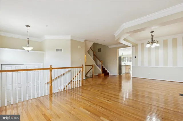 a view of a room with wooden floor staircase and a kitchen