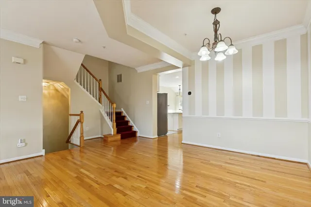 a view of a room with wooden floor and ceiling fan