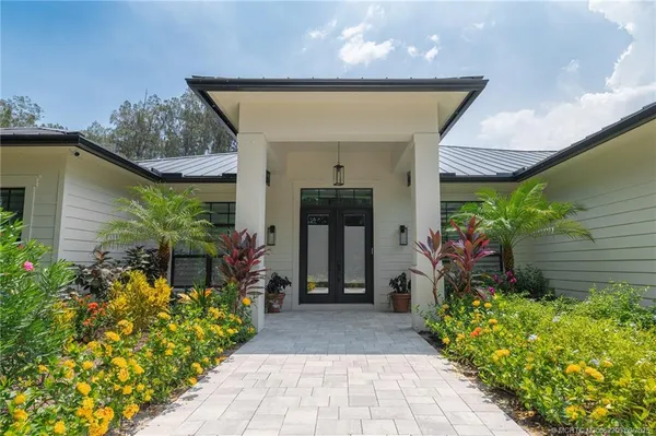 a front view of a house with plants