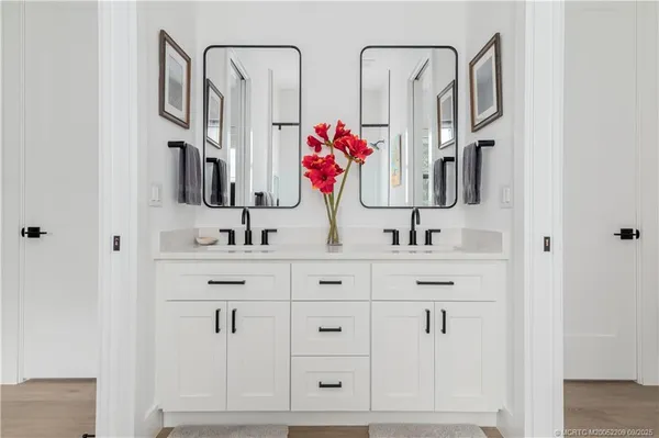 a bathroom with double vanity sink a mirror and shower