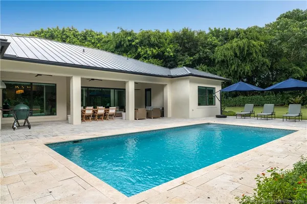 a living room with patio furniture and a garden