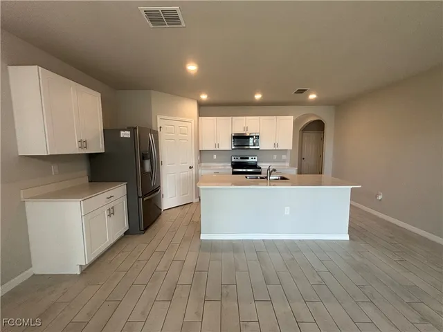 a kitchen with stainless steel appliances a refrigerator stove microwave and cabinets
