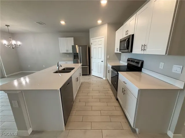a kitchen with a sink a counter top space stainless steel appliances and cabinets