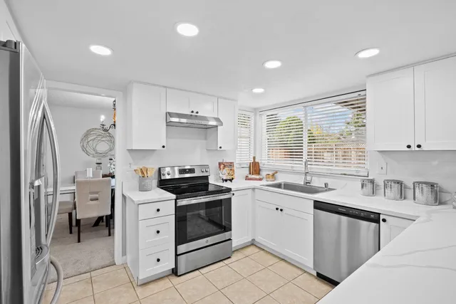 a kitchen that has a lot of cabinets in it and wooden floors