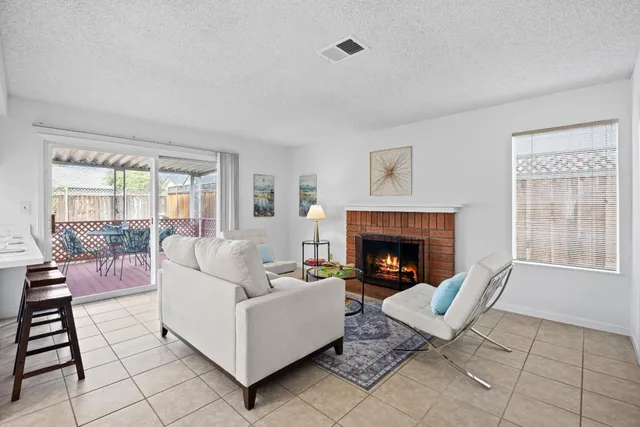 a living room with furniture a fireplace and next to a window