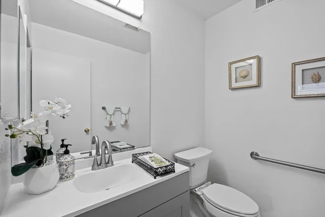 a bathroom with a granite countertop toilet sink and mirror
