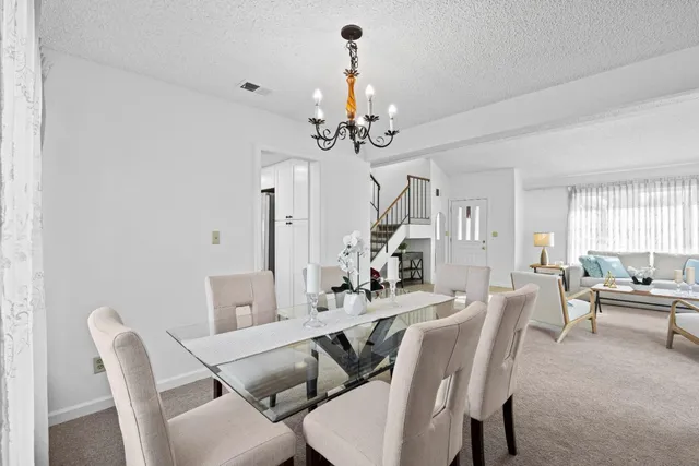 a view of a dining room with furniture and a chandelier