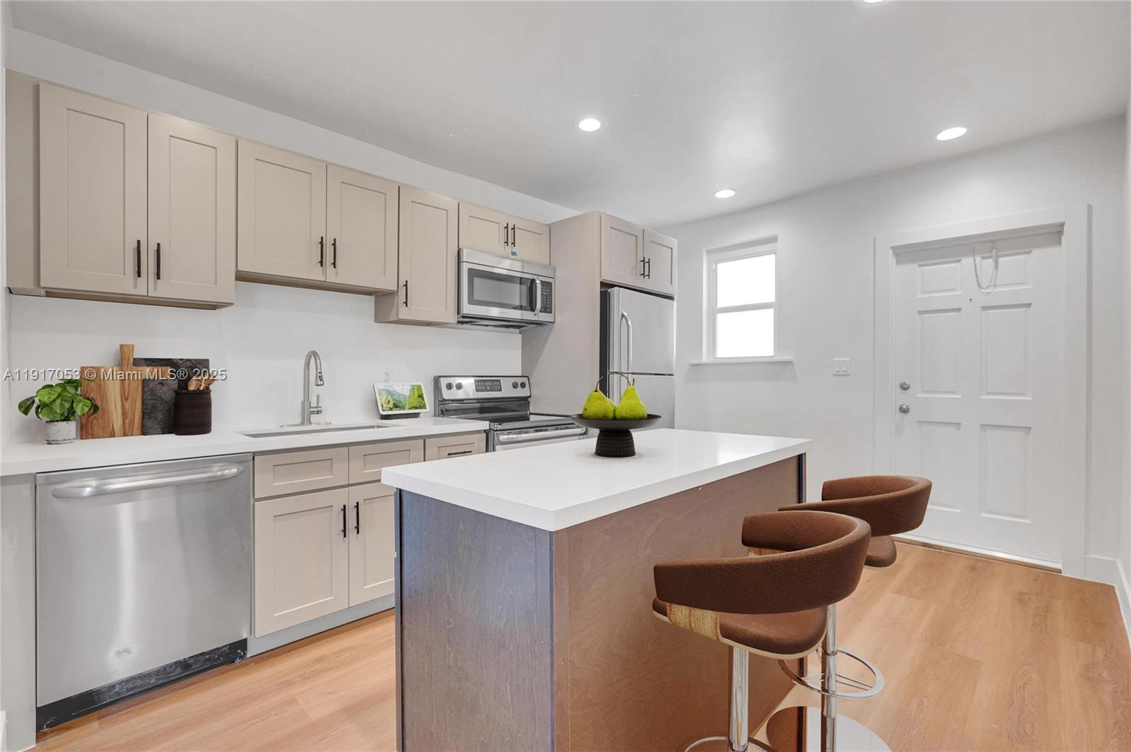 893 Northeast 81st Street, Unit 2 Miami, FL 33138 - Photo 4 of 7 a kitchen with a sink cabinets and wooden floor