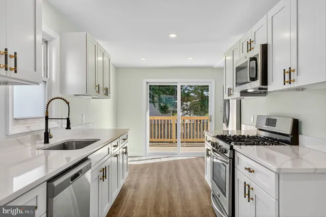 a kitchen with stainless steel appliances kitchen island granite countertop a stove and a sink