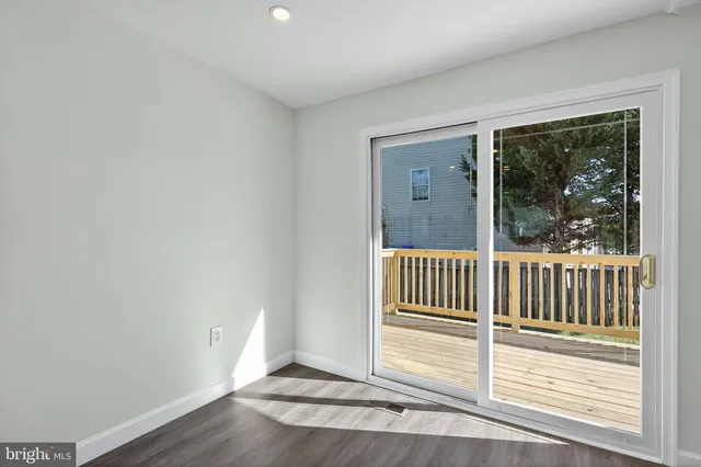 a view of a room with wooden floor and a window