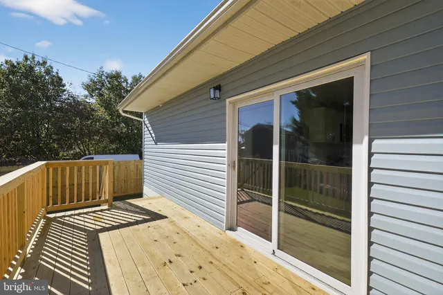 a view of a balcony with a floor to ceiling window and wooden fence