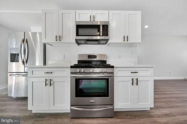 a kitchen with stainless steel appliances a stove microwave and sink