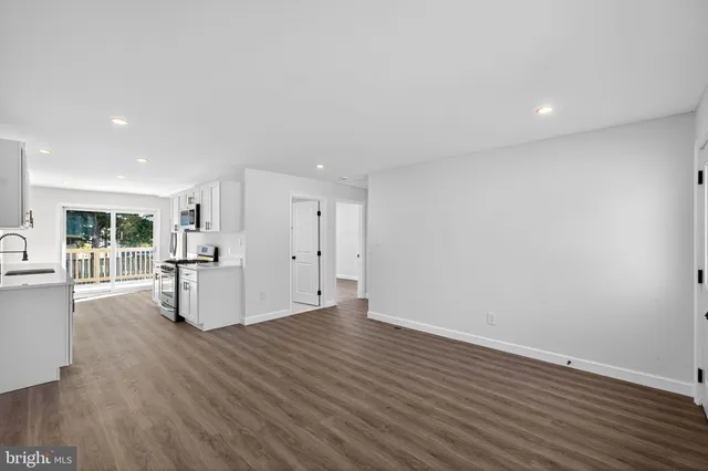 a view of empty room with wooden floor and window
