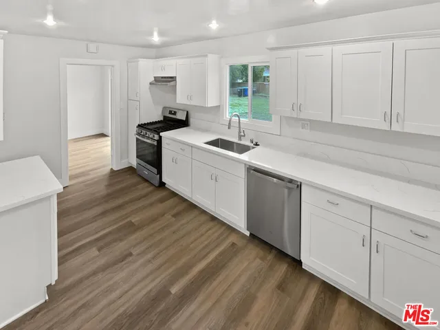 a kitchen with a sink cabinets and window