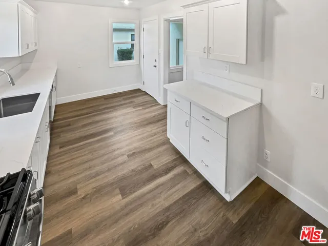 a kitchen with wooden floors and white appliances