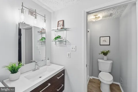 a bathroom with a granite countertop sink toilet and a mirror