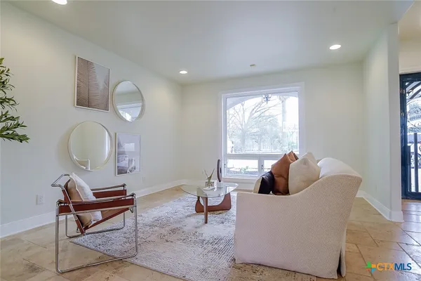 a living room with furniture a rug and a large window