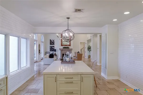 a kitchen with a table chairs and a chandelier