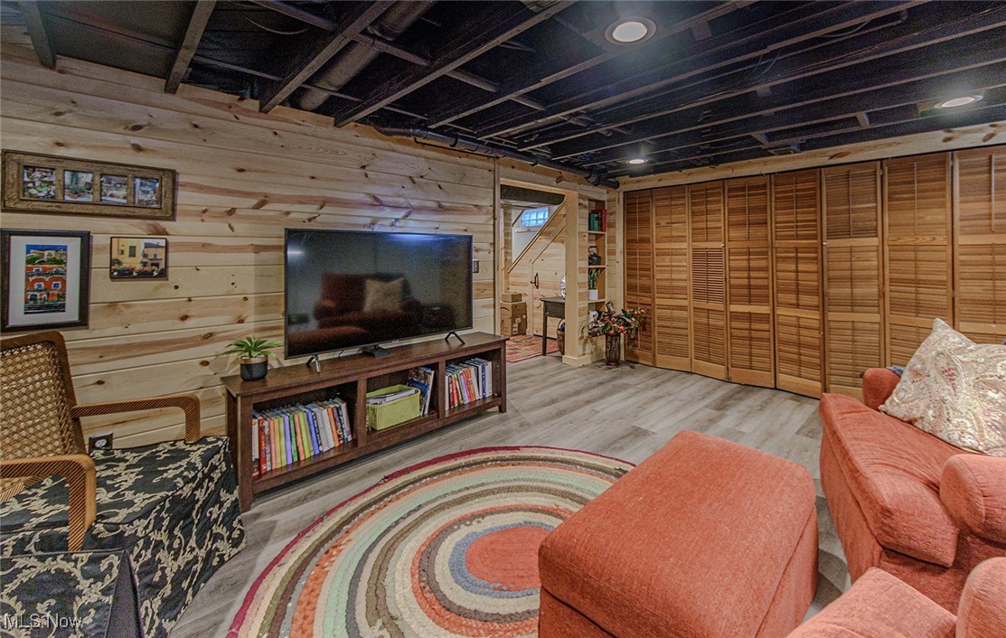 696 Ecton Road Akron, OH 44303 - Photo 29 of 41 The pine paneling and black ceiling bring a modern feel to this level. Behind the slated folding doors, more storage.