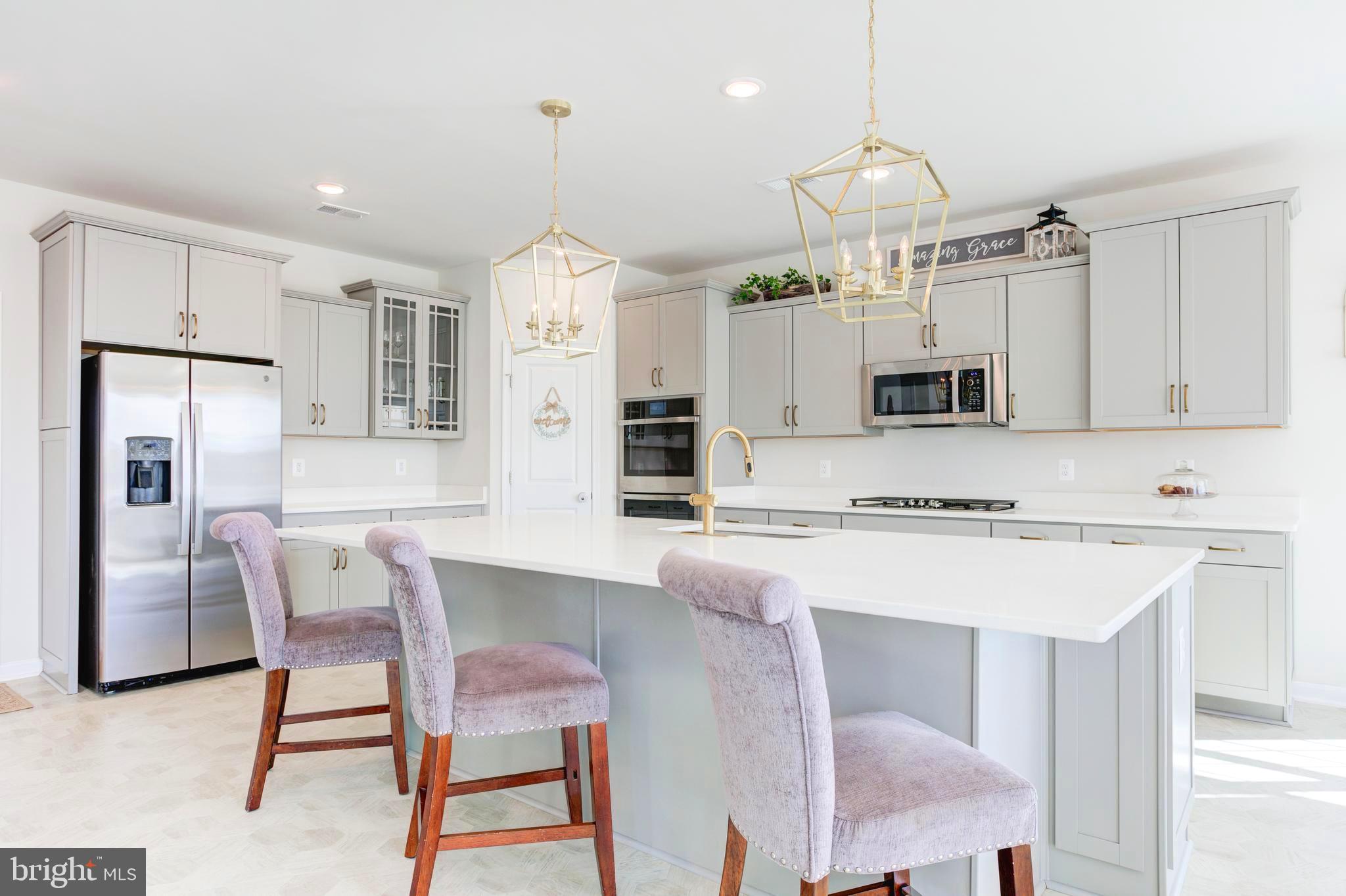 13402 Maymount Drive Culpeper, VA 22701 - Photo 15 of 25 a kitchen with a dining table chairs refrigerator and microwave
