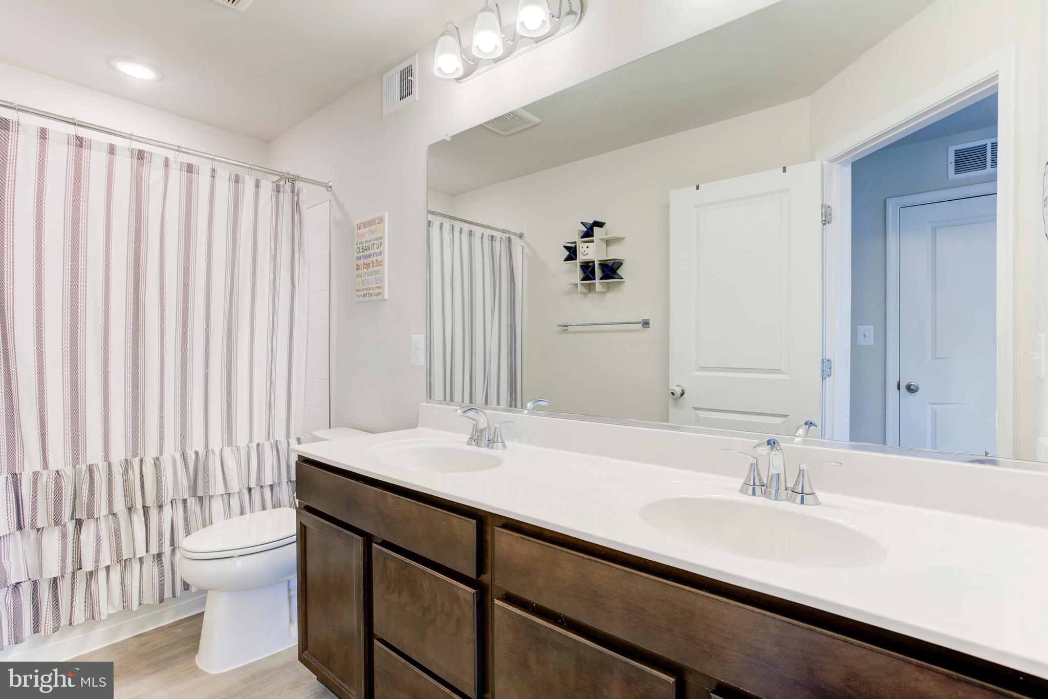 13402 Maymount Drive Culpeper, VA 22701 - Photo 23 of 25 a bathroom with a double vanity sink toilet and a mirror