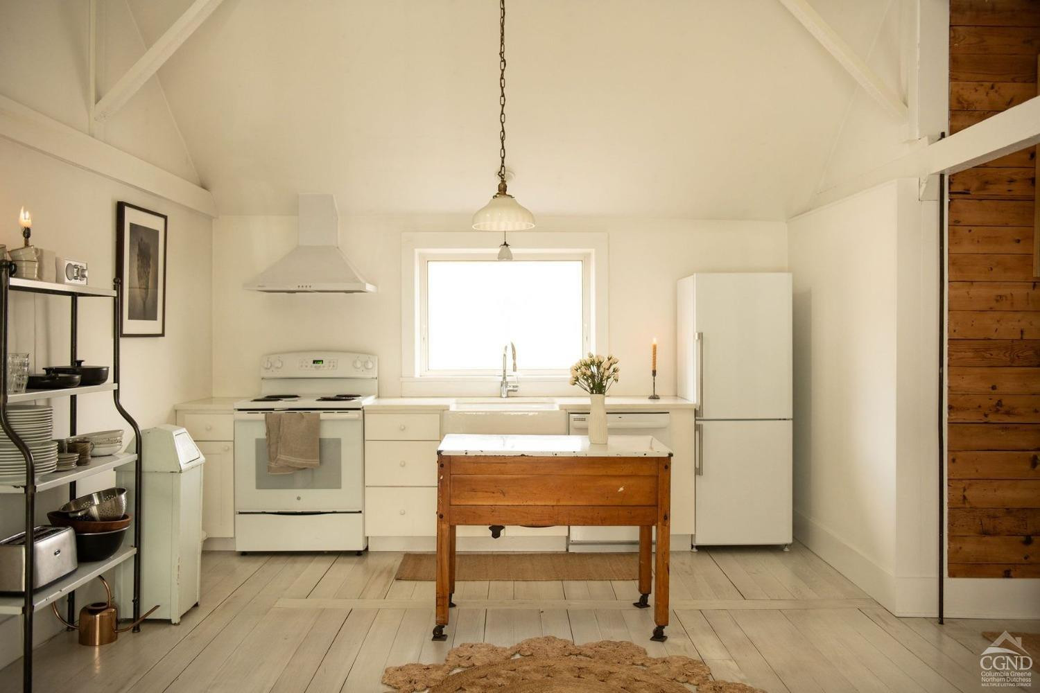 222 Main Street Germantown, NY 12526 - Photo 21 of 36 a kitchen with stainless steel appliances kitchen island granite countertop a stove a refrigerator and white cabinets with wooden floors