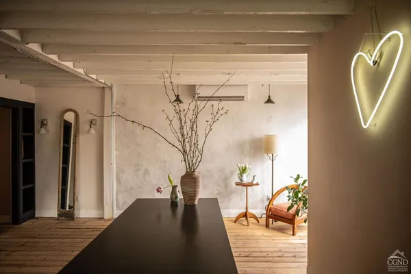 a view of a hallway with wooden floor and a living room