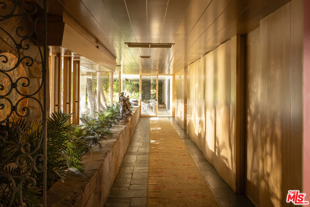 1018 North Crescent Drive Beverly Hills, CA 90210 - Photo 7 of 18 a hallway with a large window and painted walls