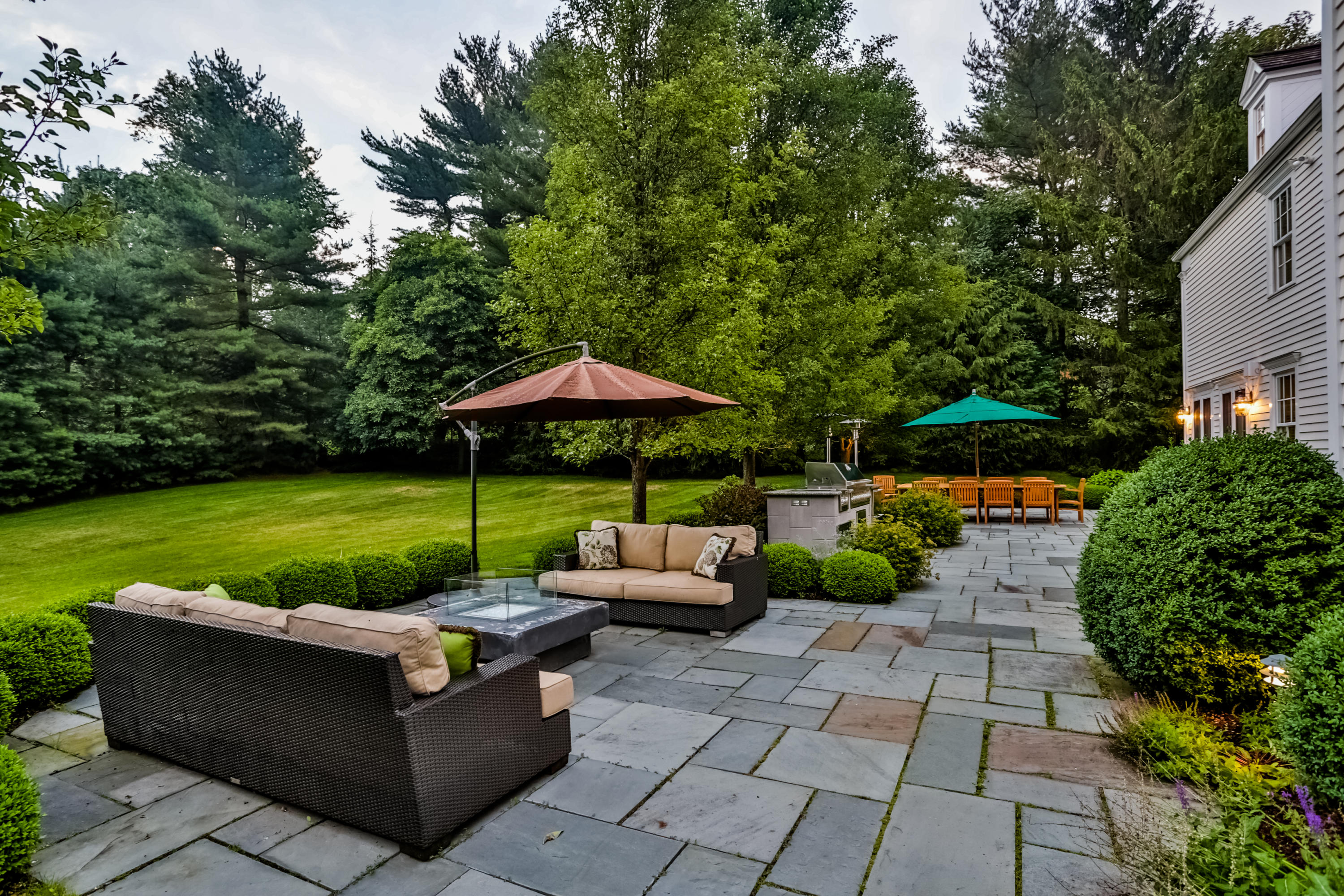 170 Brushy Ridge Road New Canaan, CT 06840 - Photo 50 of 56 a view of a patio with couches and a table and chairs under an umbrella