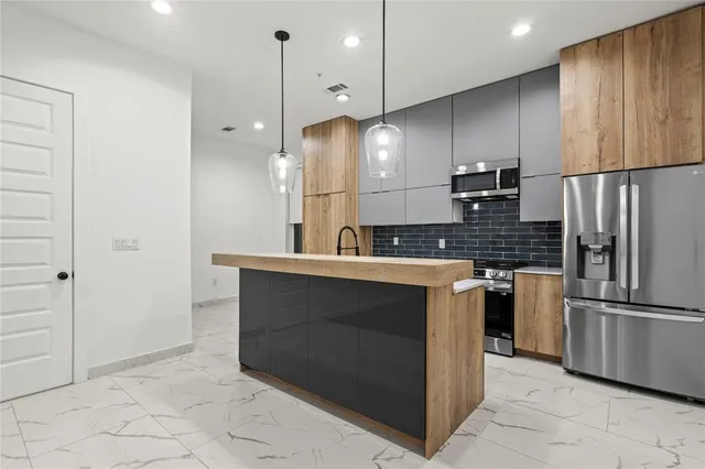 a kitchen with stainless steel appliances a sink a stove a refrigerator and cabinets