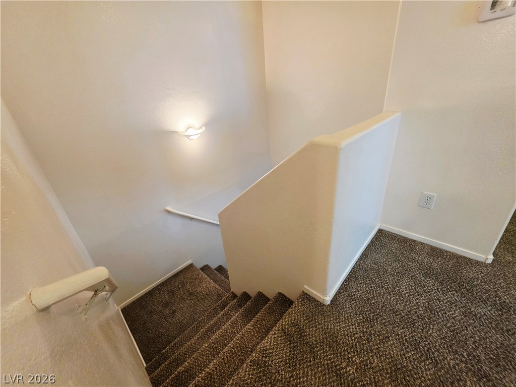 1571 Rusty Ridge Lane Henderson, NV 89002 - Photo 25 of 26 A well-lit stairway with durable carpeted treads and a sturdy wall-mounted handrail provides safe passage.