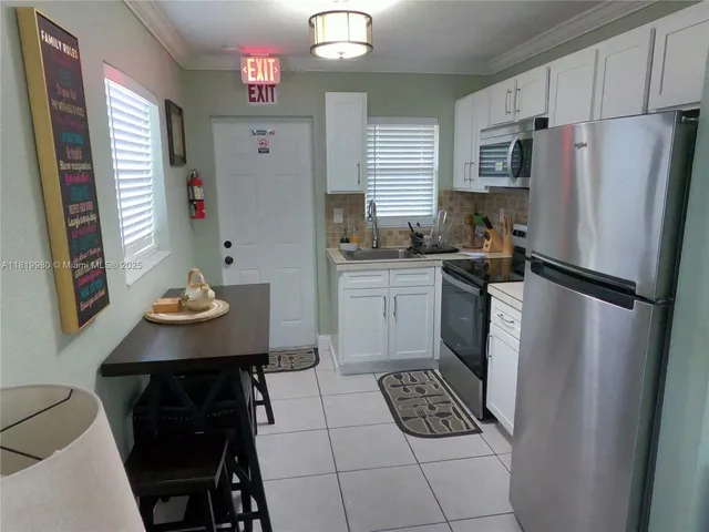 a kitchen with stainless steel appliances a refrigerator sink stove microwave and cabinets