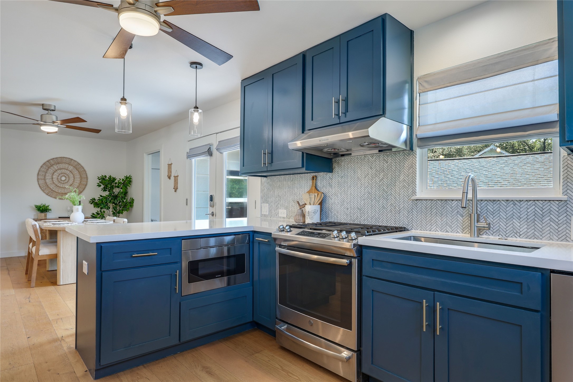5203 Ledesma Road Austin, TX 78721 - Photo 12 of 40 A well-appointed kitchen showcasing elegant blue cabinetry and integrated appliances for modern culinary pursuits.