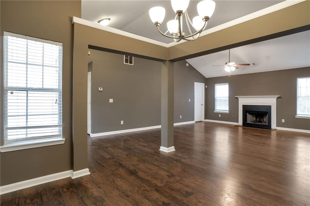 4598 Jackam Ridge Court Lithonia, GA 30038 - Photo 16 of 25 an empty room with wooden floor chandelier and windows