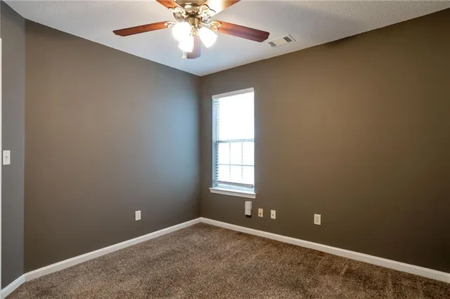 an empty room and chandelier fan