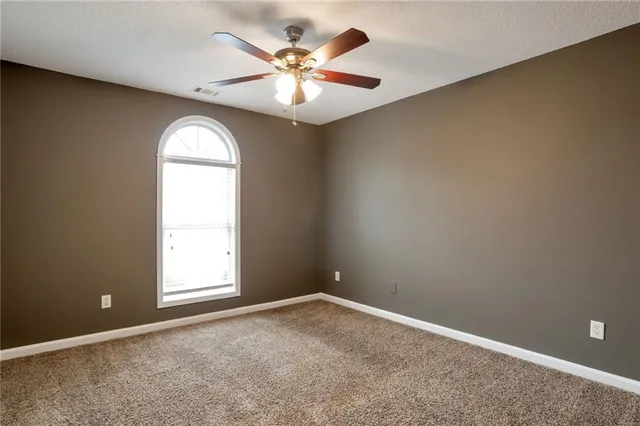 an empty room and chandelier fan