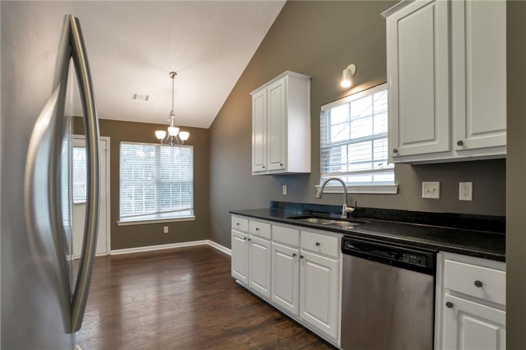 4598 Jackam Ridge Court Lithonia, GA 30038 - Photo 6 of 25 a kitchen with stainless steel appliances granite countertop a sink a stove a refrigerator a microwave and cabinets