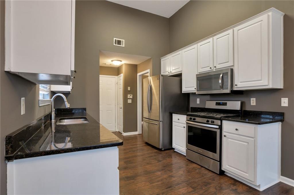4598 Jackam Ridge Court Lithonia, GA 30038 - Photo 7 of 25 a kitchen with stainless steel appliances granite countertop a sink stove and refrigerator