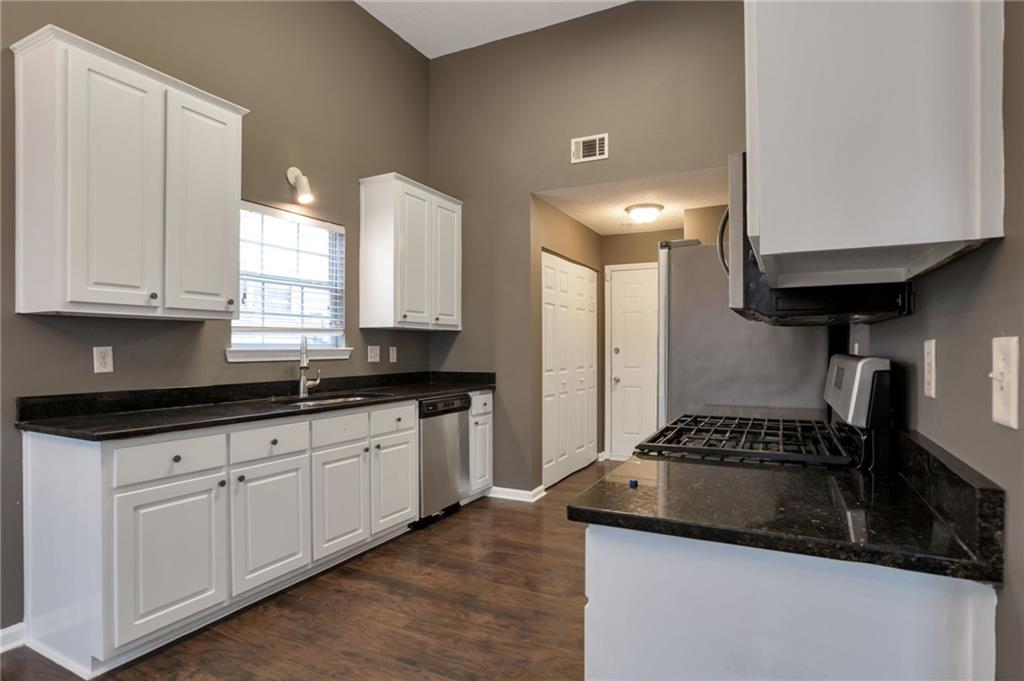 4598 Jackam Ridge Court Lithonia, GA 30038 - Photo 8 of 25 a kitchen with granite countertop a sink a stove and cabinets