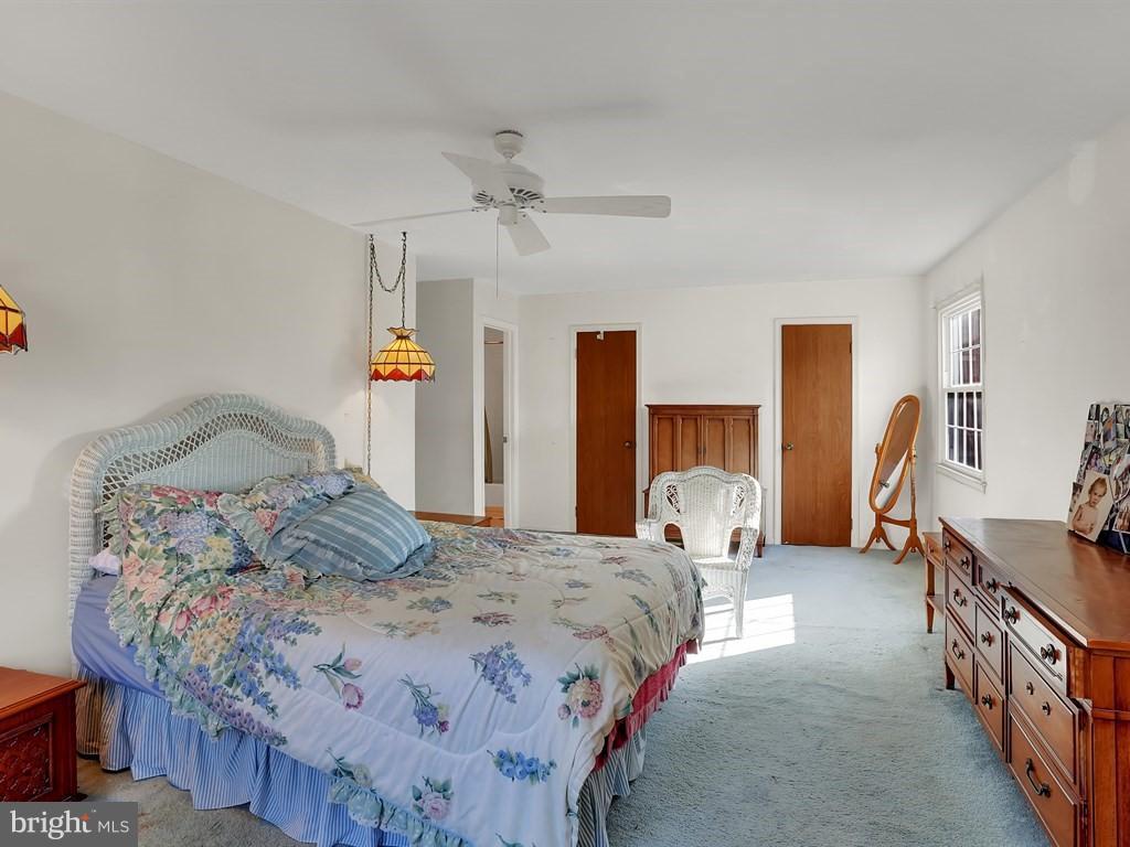 9115 Rockefeller Lane Springfield, VA 22153 - Photo 21 of 29 a bedroom with a bed and a chandelier