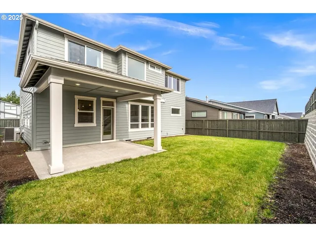a view of an house with backyard space and balcony