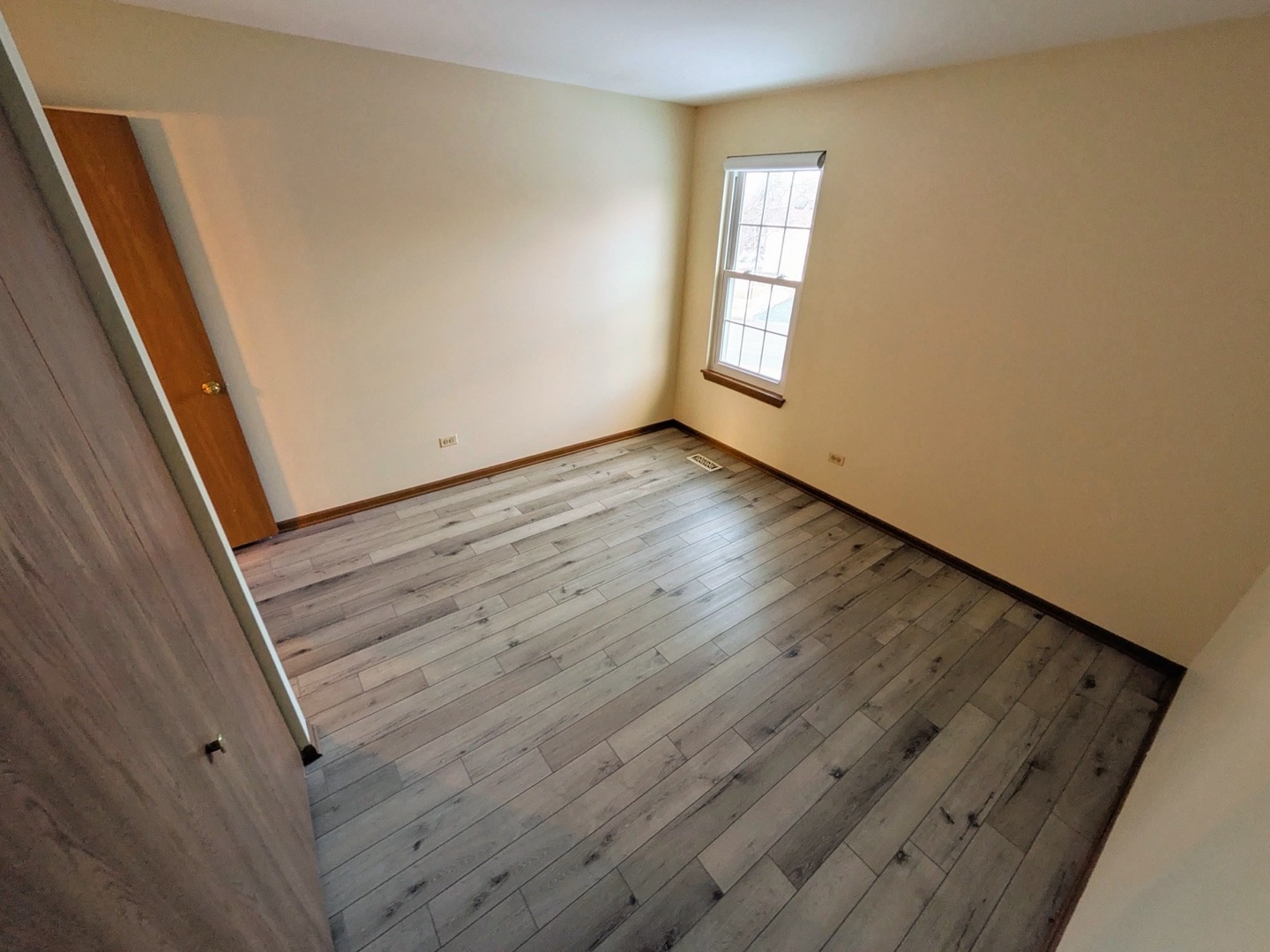 28 North Oltendorf Road, Unit 28 Streamwood, IL 60107 - Photo 7 of 13 a view of an empty room with wooden floor and a window