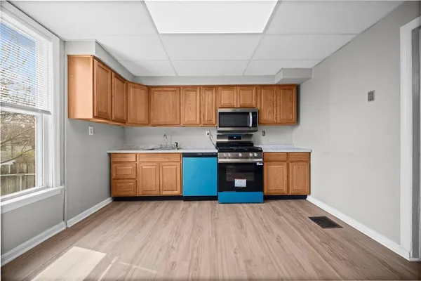 a kitchen with stainless steel appliances a sink cabinets and wooden floor
