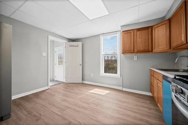 a view of a kitchen with wooden floor and a window
