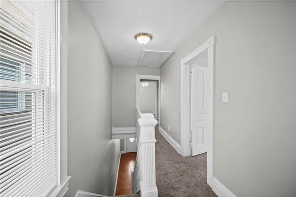 a view of a hallway with toilet and shower