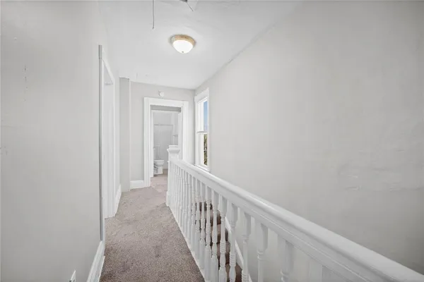 a view of a hallway with a white walls and stairs