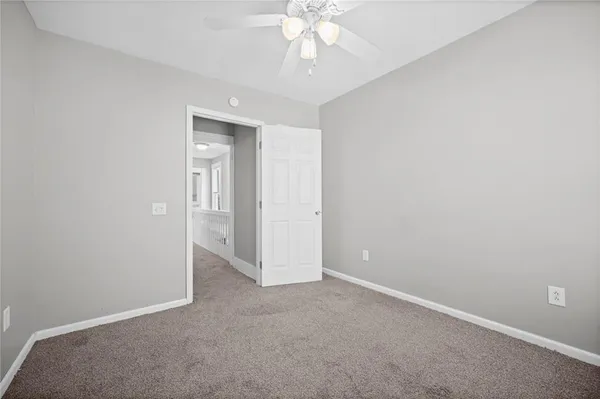 an empty room with closet and a chandelier fan
